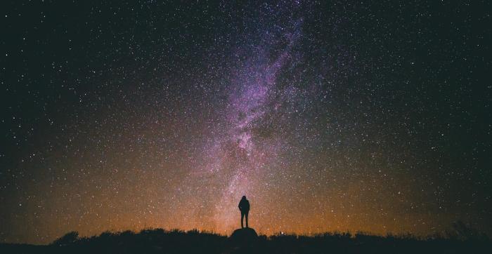 A silhouetted person stood in front of stars