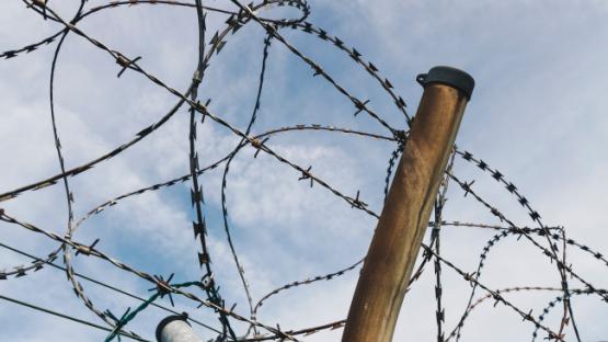 Barbed wire and fence on sky background