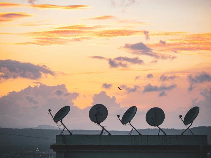 Satellite dishes against sunset background