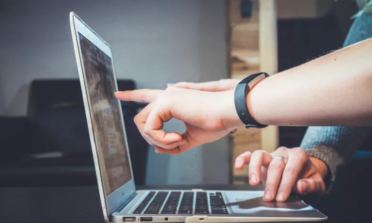 People pointing at laptop screen