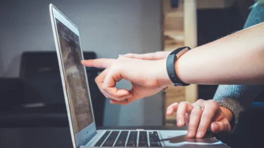 People pointing at laptop screen