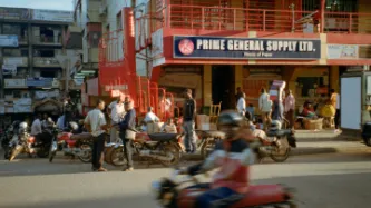 A group of BodaBoda drivers wait for customers outside a shop in Kampala