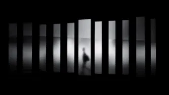 Man walking behind bars