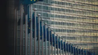 A curved row of EU flags in front of an office building